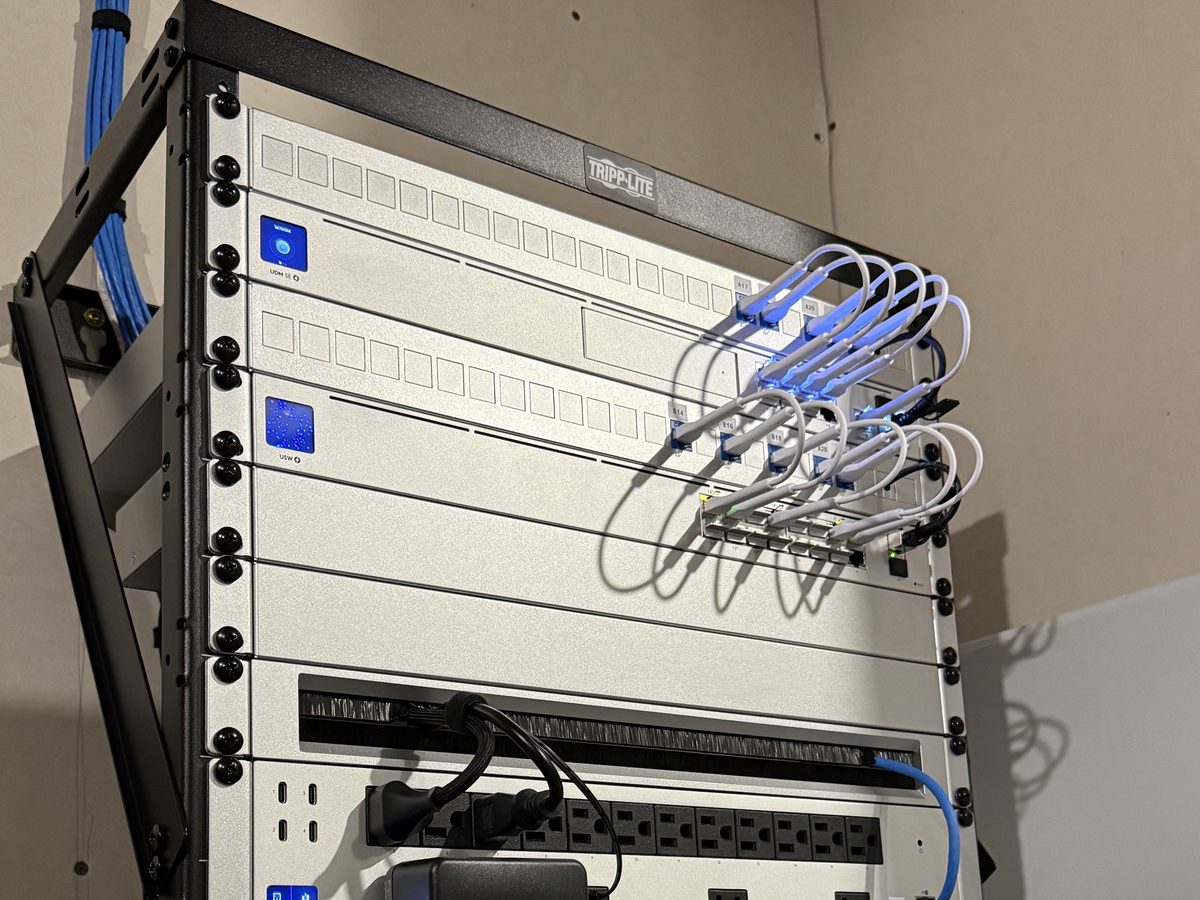 Wall-mounted UniFi network rack with switches and short patch cables in Sioux Falls, SD