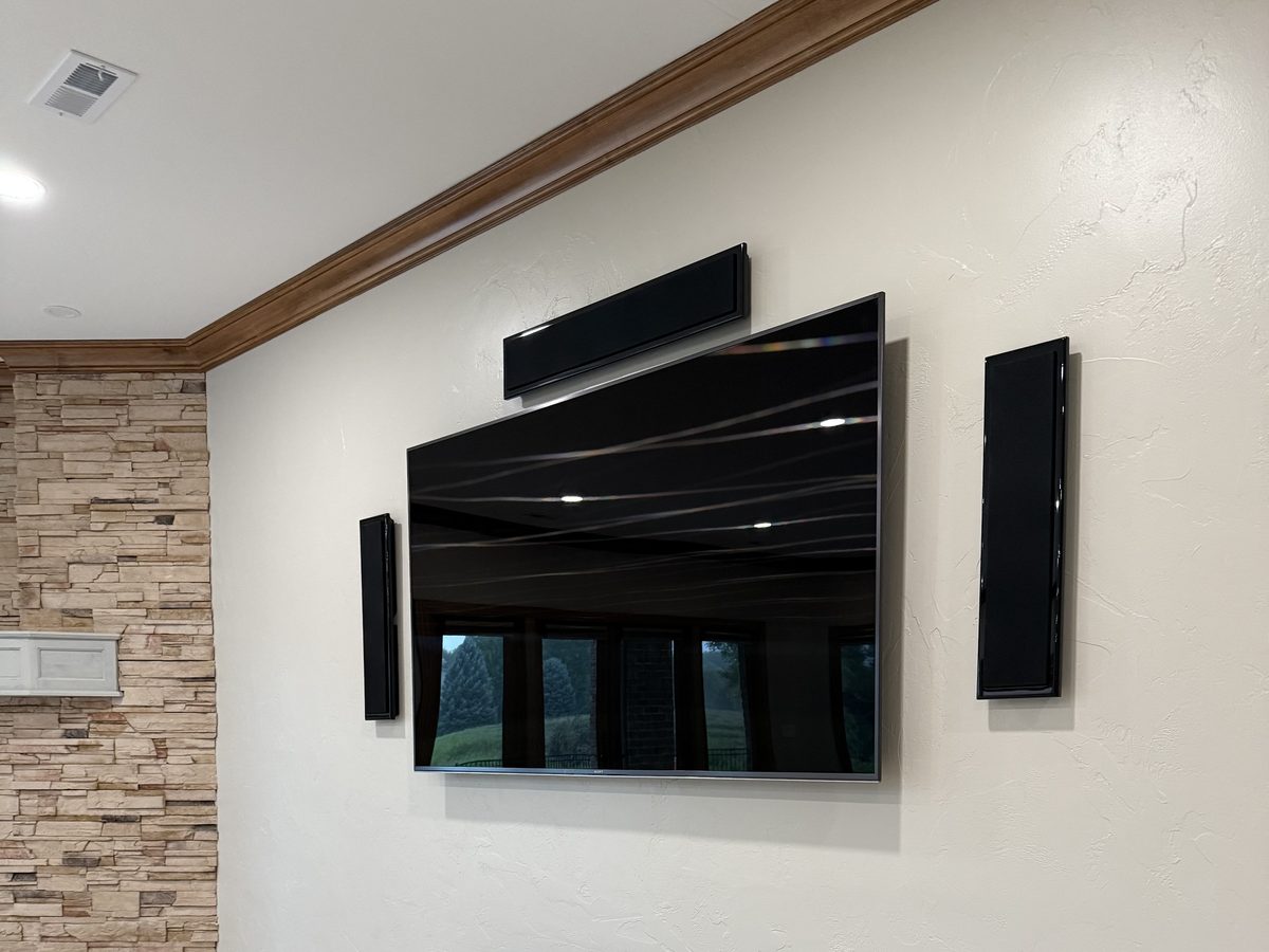 Wall-mounted TV with on-wall left, center and right speakers in a Sioux Falls, SD home